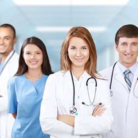 A female doctor with a female nurse and two male doctors behind her